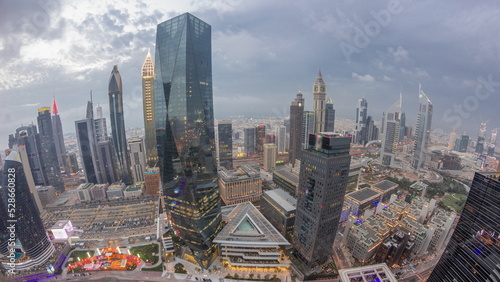 Panorama of futuristic skyscrapers after sunset in financial district business center in Dubai day to night timelapse