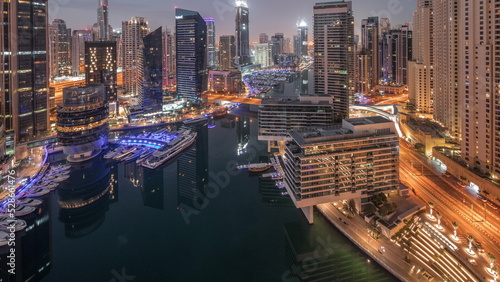 Photography Aerial view to Dubai marina skyscrapers around canal with floating boats night t