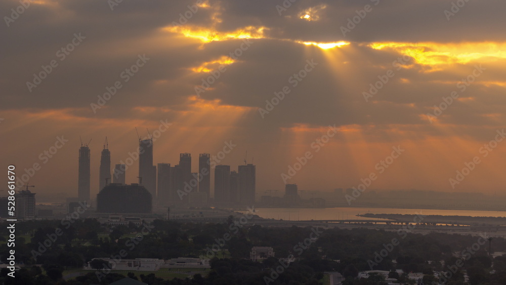 Sunrise over Dubai Creek Harbor with skyscrapers and towers under construction aerial timelapse