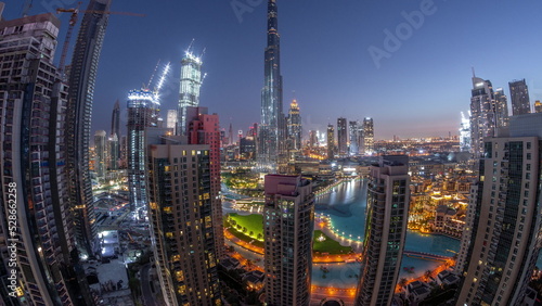 Panorama of Dubai Downtown cityscape with tallest skyscrapers around aerial night to day timelapse.