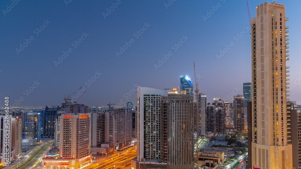 Skyscrapers at the Business Bay in Dubai aerial day to night timelapse, United Arab Emirates