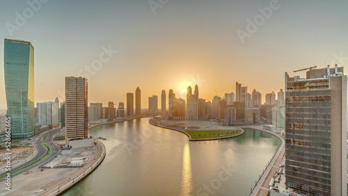 Sunset cityscape of skyscrapers in Dubai Business Bay with water canal aerial timelapse