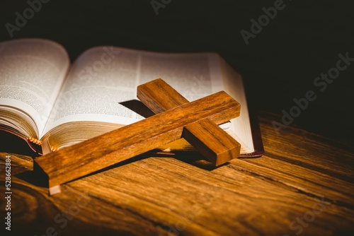 Wooden cross kept on open bible 