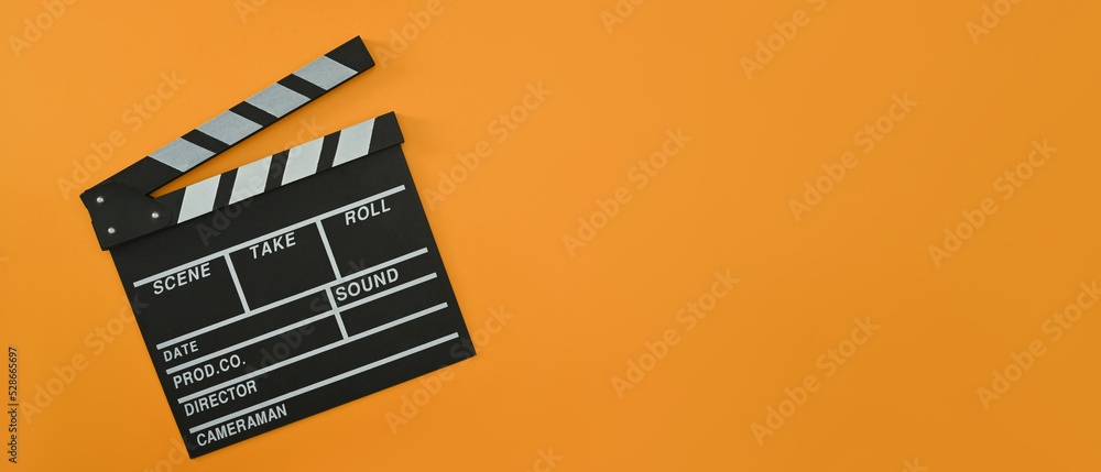 A clapper board on orange background with copy space. Cinema minimal concept