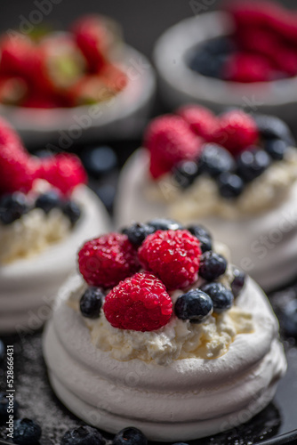 Mini Pavlova cakes topped with berries and mascarpone cheese