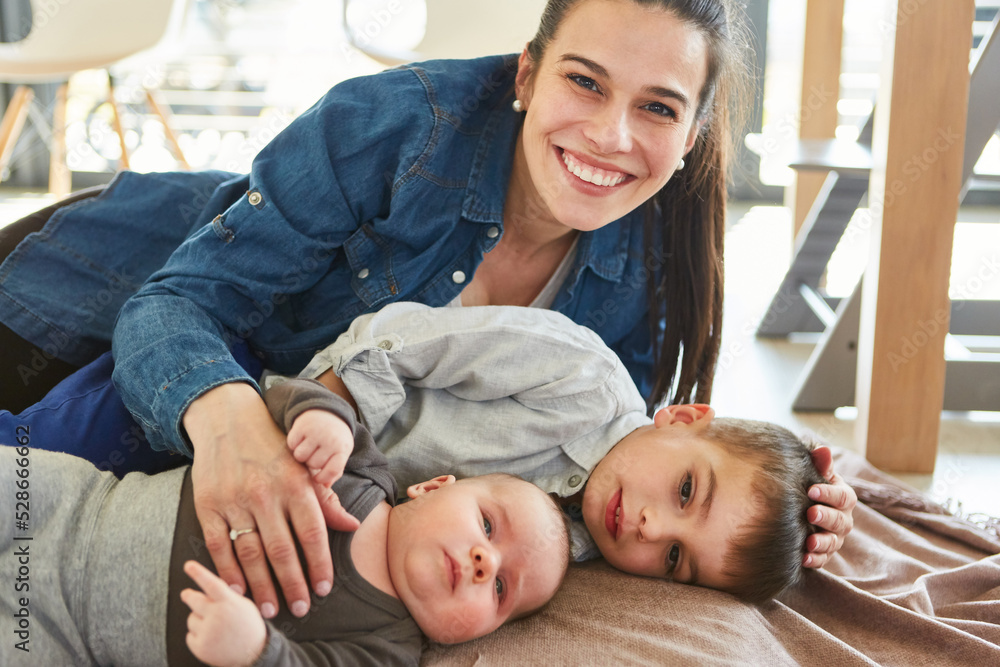 Obraz premium Single mother cuddles with baby and child