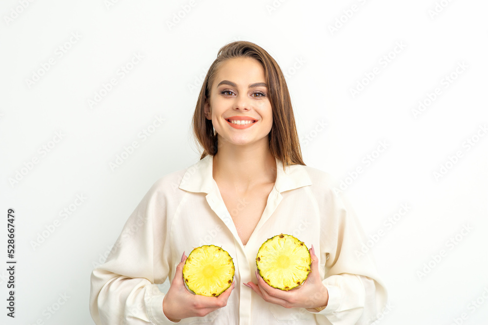 Young Caucasian smiling woman holding slices pineapple over white background, breast health concept Young Caucasian smiling woman holding slices pineapple over white background, breast health concept
