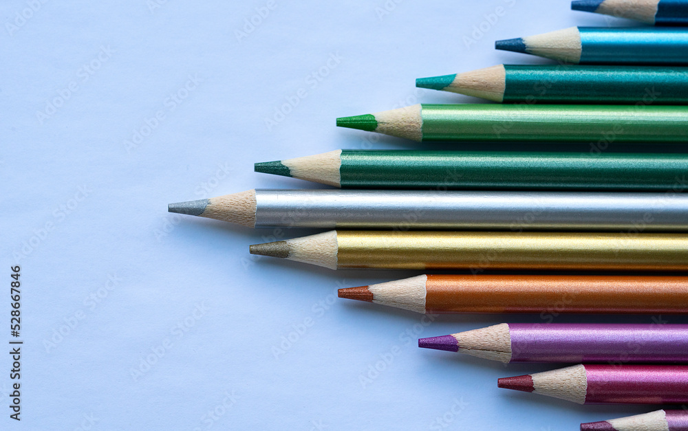 Fototapeta premium Colored pencils with a metallic sheen close-up. Background with place for text. High quality photo