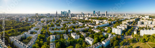 Piękny panoramiczny widok z drona na centrum nowoczesnej Warszawy z sylwetkami drapaczy chmur. Na pierwszym planie Muranów – zielona dzielnica Warszawy. #528668275