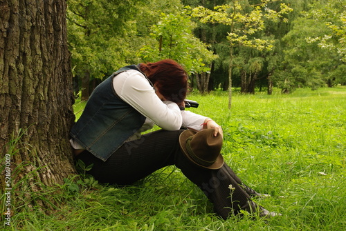 desperate person sitting on the grass with a gun
