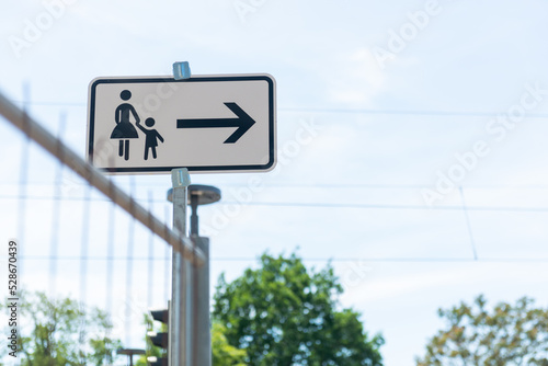 mother and child crossing sign. passengers change street side arrow signpost closeup