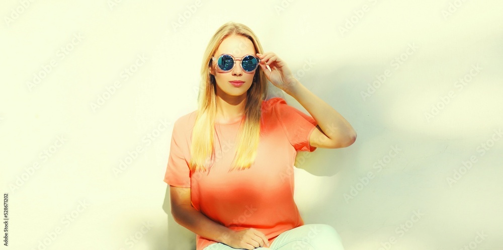 Summer portrait of stylish blonde young woman wearing sunglasses in the city Summer portrait of stylish blonde young woman wearing sunglasses in the city