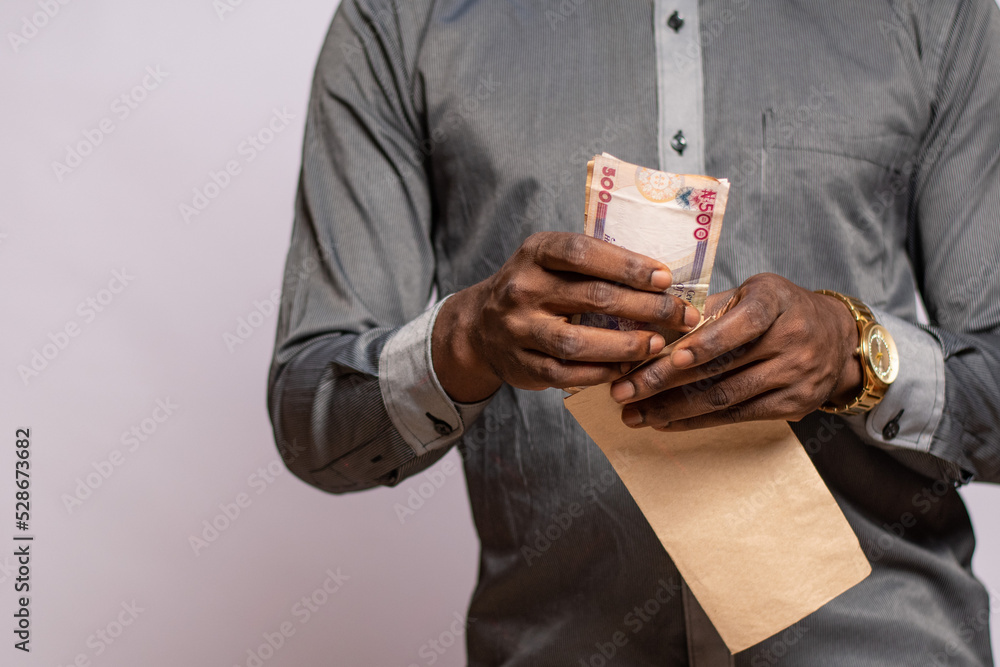 african man holding and envelope containing money african man holding and envelope containing money
