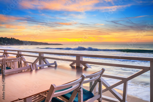 Slika na platnu Seaside landscape - the cafe on the embankment with views of the sunrise over th