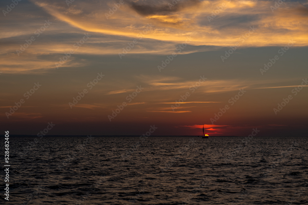 smutna żaglówka na tle zachodzącego nad Bałtykiem słońca