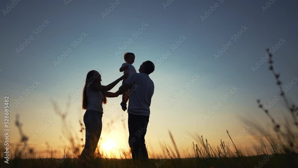 happy family in the park. father and mother raise son up play play with child silhouette. happy family kid a dream concept. friendly family playing with lifestyle baby outdoors in the park happy family in the park. father and mother raise son up play play with child silhouette. happy family kid a dream concept. friendly family playing with lifestyle baby outdoors in the park