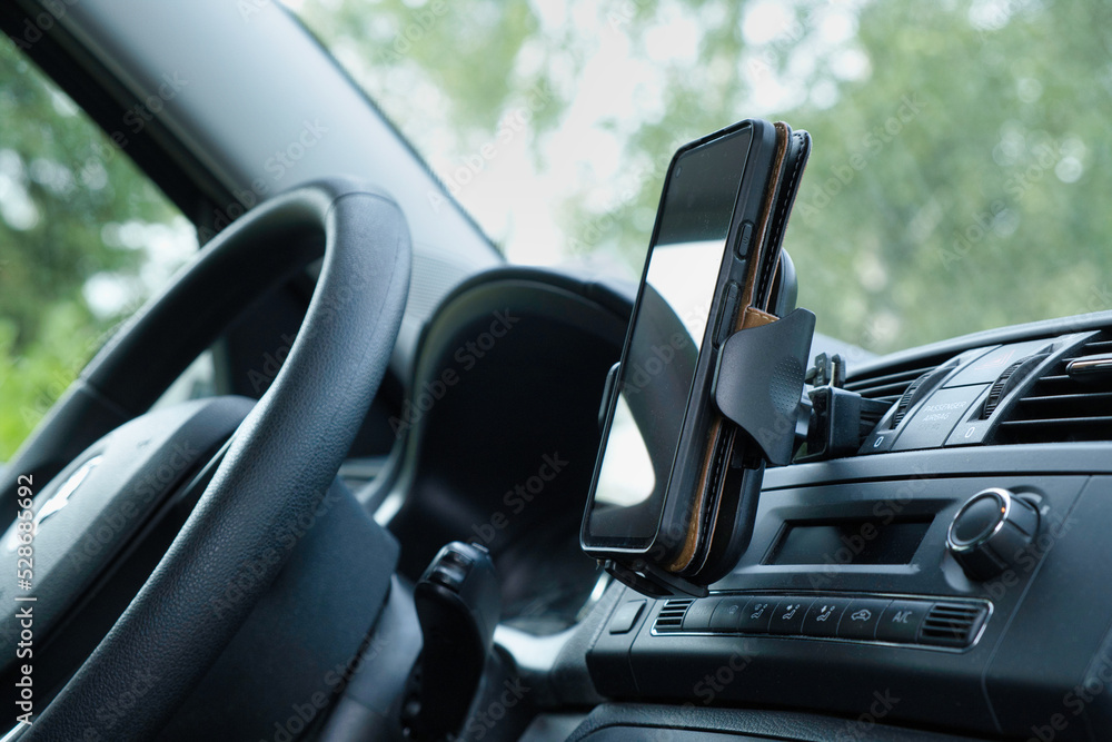 Plastic car phone holder with smartphone in a car Plastic car phone holder with smartphone in a car