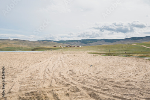 Narrow strip of sand on the beach on coasts of Lake Baikal 