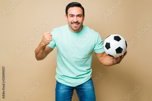 Attractive young man enjoying watching the soccer game and looking excited © AntonioDiaz
