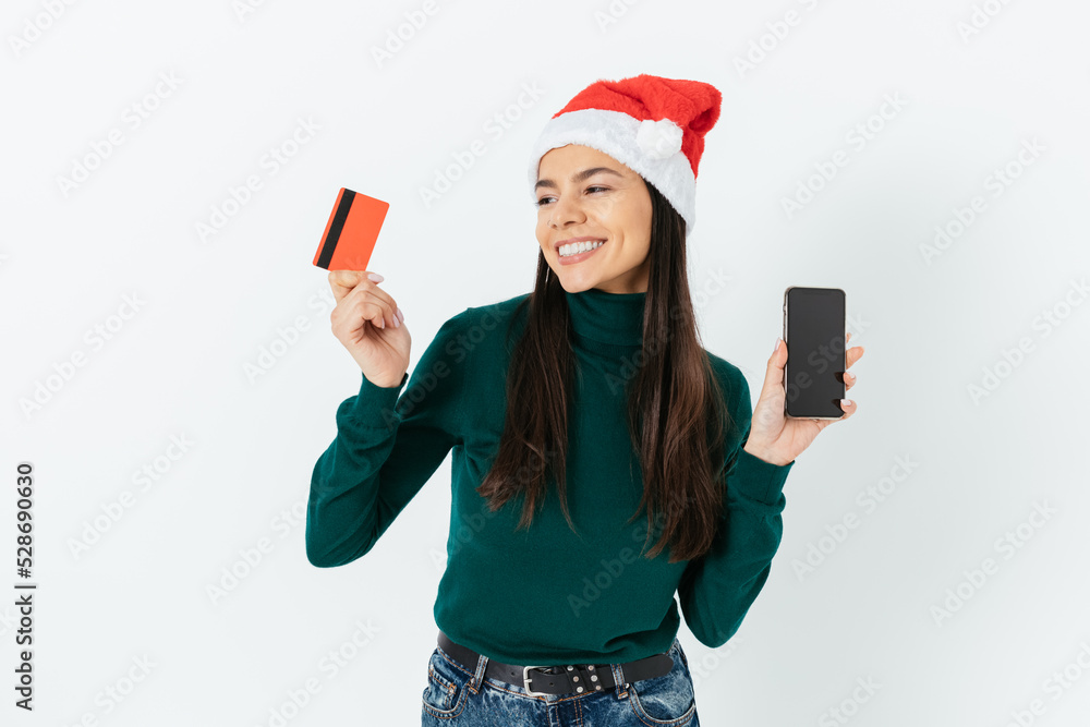 Christmas shopping online. Happy young woman wearing red santa hat Christmas shopping online. Happy young woman wearing red santa hat