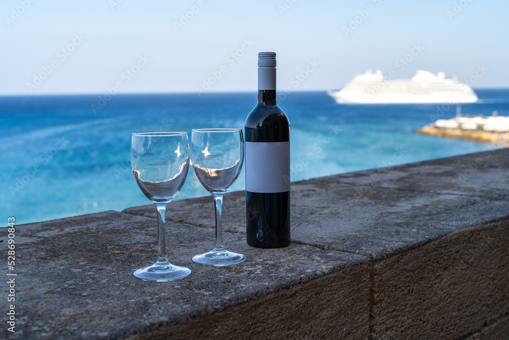 Wine and two glasses on the background of the sea on the balcony Wine and two glasses on the background of the sea on the balcony