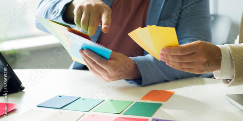 business people choose color during brainstorming in the office. close up of partners colleagues hands during meeting with color palettes. color choice for future product construction idea.