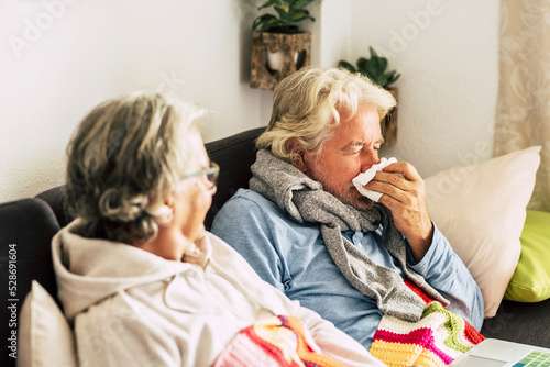 Fotobehang Two person man and woman old age with influenza flu symptoms at home healing and helping each other
