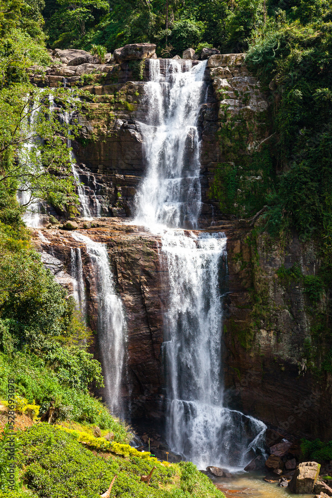 Obraz premium Grandiose unusually beautiful waterfall in the green jungle of the island of Sri Lanka