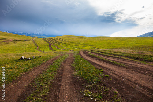 Obraz na płótnie A bunch of winding roads among the green hills in the valley of the charming plateau of Assy under thunderclouds w salonie