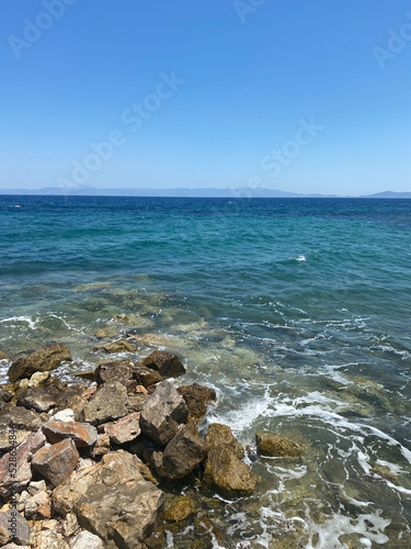 Beautiful view of the rocky beach and the skyline, blue water in the sea and clear sky