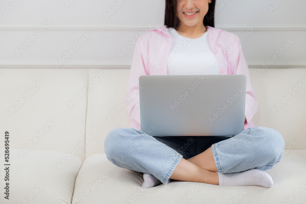 Young asian business woman work from home with laptop computer online to internet on sofa in living room, freelance girl using notebook sitting on couch with comfort and relax, lifestyles concept. Young asian business woman work from home with laptop computer online to internet on sofa in living room, freelance girl using notebook sitting on couch with comfort and relax, lifestyles concept.