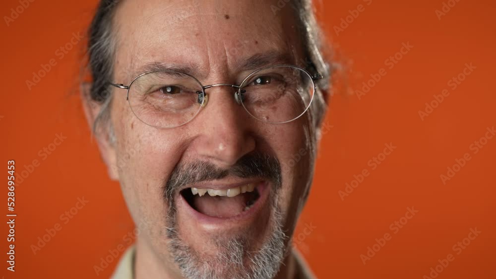 Closeup portrait of smiling happy mature man on isolated on solid orange background. Closeup portrait of smiling happy mature man on isolated on solid orange background.