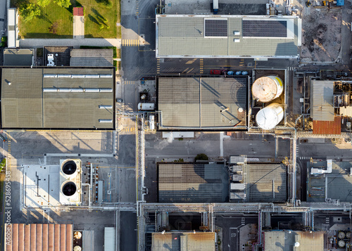 Bird's eye shot with drone, FIS chemical plant Gambellara (VI) Italy, September 05 2022 in the late afternoon. We see the production plants, liquid transport system and storage pipes, evaporative towe