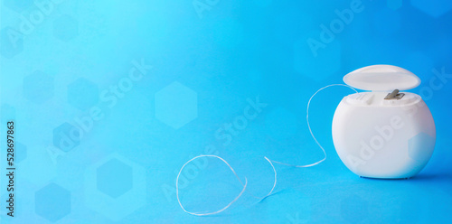 Dental floss on a blue bokeh effect background.