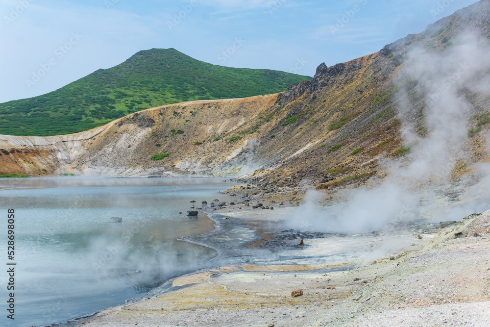 hot mineralized lake with thermal spring and smoking fumaroles in the caldera of the Golovnin volcano on the island of Kunashir