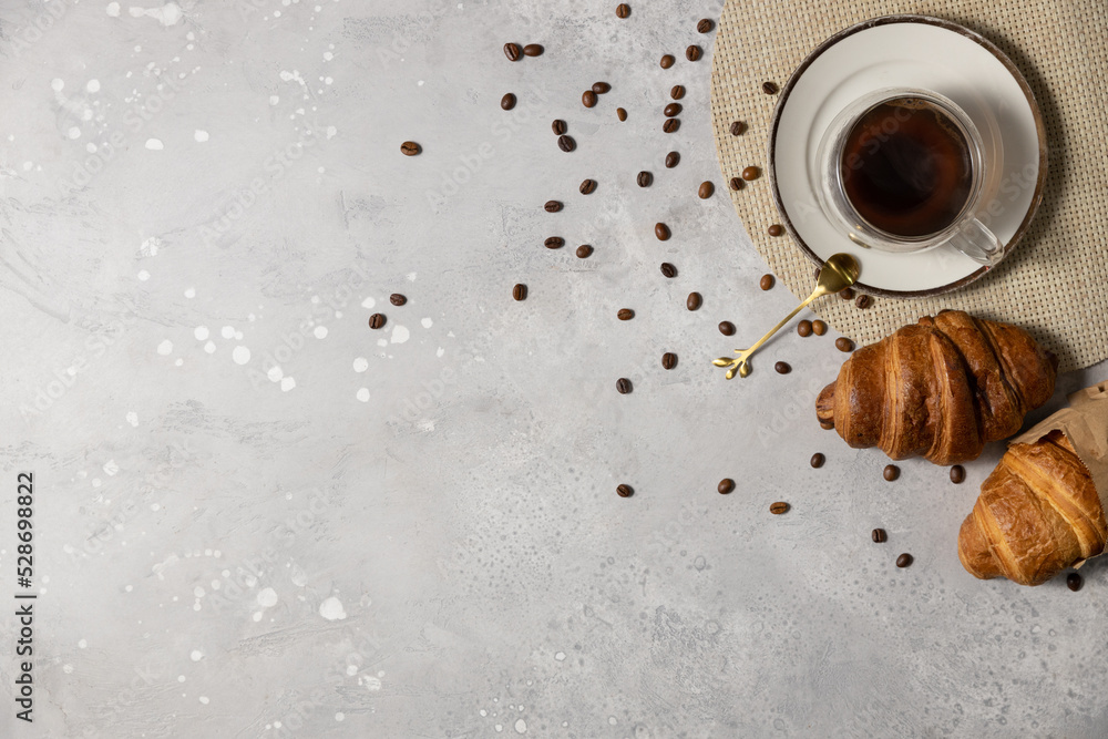 Fototapeta premium Tasty fresh croissants and coffee on light grey marble table, flat lay. Space for text