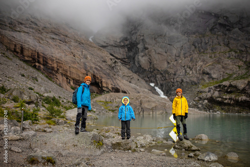 Child, cute blond boy, toddler enjoying the amazing view of glacier in Jostedalsbreen national park