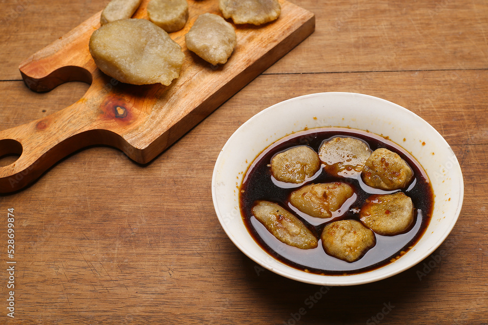 Fototapeta premium empek empek with cuka or vinegar sauce in a white bowl. emepek enpek is a typical food from Palembang Indonesia. pempek palembang. Indonesian dish
