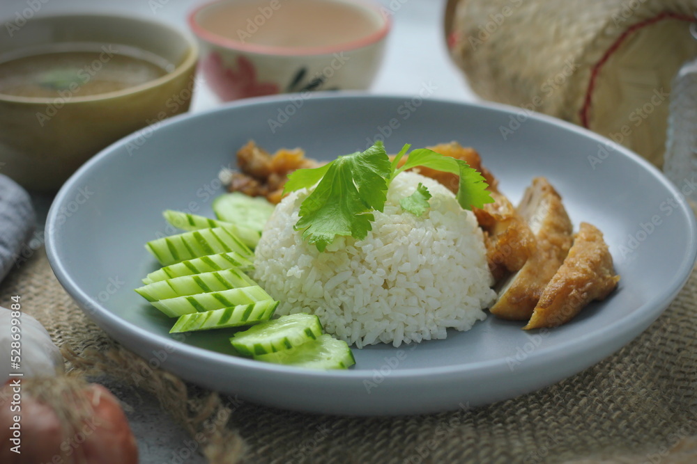 Hainanese chicken rice with fried chicken, fried chicken served with sweet dipping sauce and chicken broth, Asian style, street food commonly sold in Asia. Hainanese chicken rice with fried chicken, fried chicken served with sweet dipping sauce and chicken broth, Asian style, street food commonly sold in Asia.