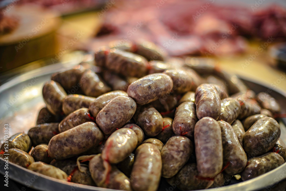 Isaan beef sausages on a tray for sale in a fresh market in Ubon Ratchathani, Thailand. Isaan beef sausages on a tray for sale in a fresh market in Ubon Ratchathani, Thailand.