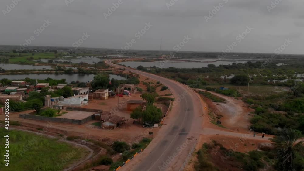 In Sindh, there is a little village located next to an s-shaped road that extends as far as the eye can see. The road is surrounded by many lakes. In Sindh, there is a little village located next to an s-shaped road that extends as far as the eye can see. The road is surrounded by many lakes.