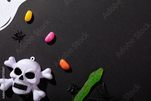 Multiple halloween candies and toys with copy space on grey background