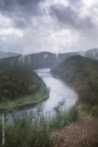 foggy morning in a hilly valley landscape river, atmospheric mood, vertical photo