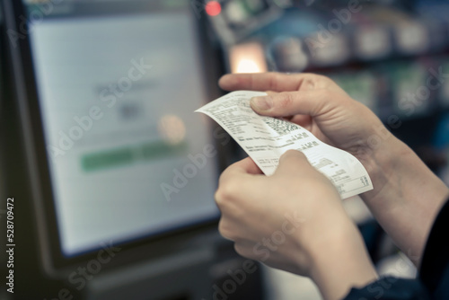 Point of Sale System For Retail product receipt in women's hands in the store - Credit Card Processor, Receipt Printer with paper shopping bill and Touch screen monitor
