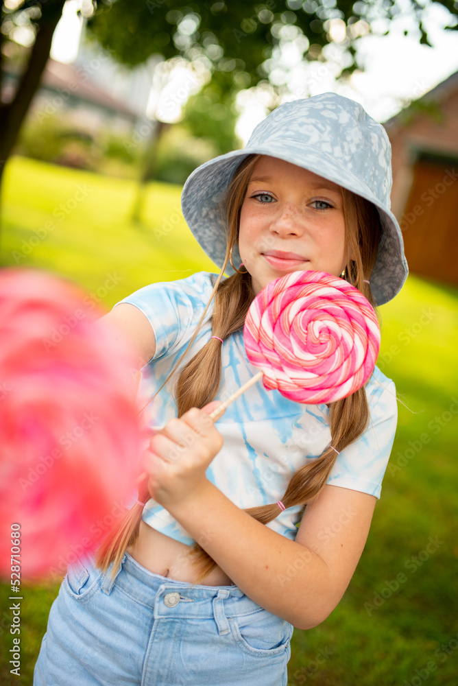 the child eats a bright lollipop. Beautiful girl model eats a bright