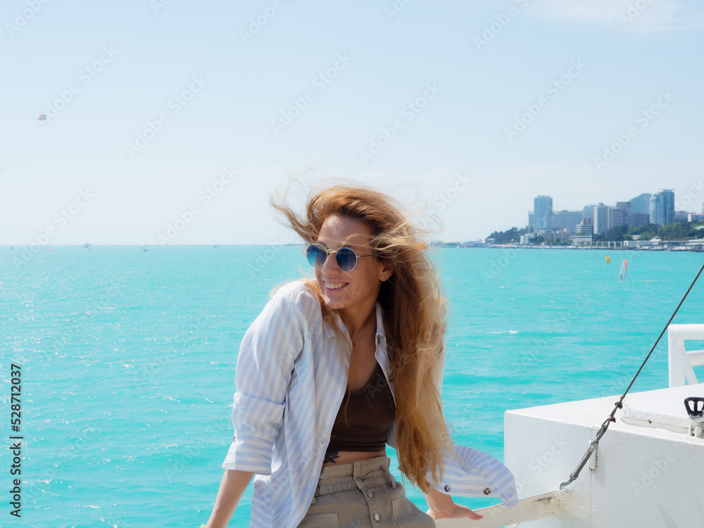 The girl is blonde, the wind blows her hair. happy girl on vacation on the ship
