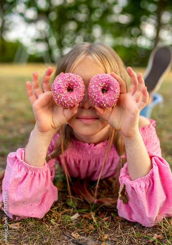 
the child eats a donut.
delicious pink donut. Bitten donut. Girl with donuts. Happy girl with freckles. Blue-eyed girl
