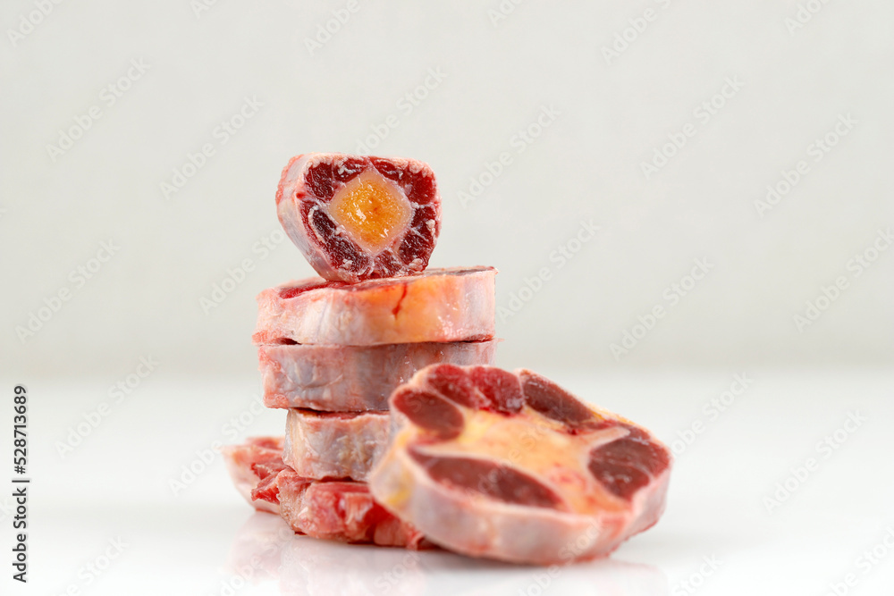 Raw Oxtail Cut, Stacked. Isolated on Cream Background with Copy Space for Text Raw Oxtail Cut, Stacked. Isolated on Cream Background with Copy Space for Text