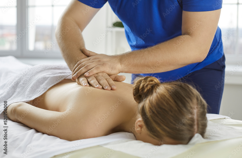 Close up of masseur massage naked female client suffering from back pain or aches. Male physiotherapist help woman patient with backache, relieve spasm or strains. Rehabilitation concept. Close up of masseur massage naked female client suffering from back pain or aches. Male physiotherapist help woman patient with backache, relieve spasm or strains. Rehabilitation concept.
