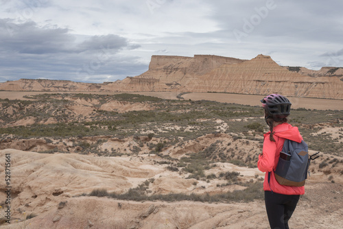Fototapeta Young woman mountain bike cyclist in Badlans of Navarre (Bardenas Reales de Navarra) dessert in the middle of Spain